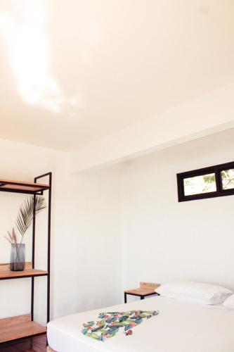a white room with a bed and a window at Yauik in Tequesquitengo