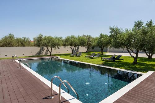 a swimming pool with a picnic table and trees at Eightyfour Living with private pool in Chania