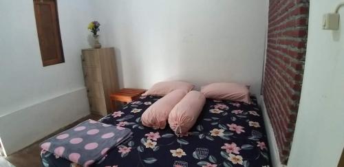 a small bed with two pillows on top of it at Ijen Farmer Homestay in Banyuwangi