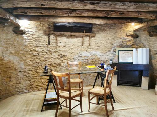 Pokój ze stołem i krzesłami w kamiennej ścianie w obiekcie La Borie du bois Sarlat w mieście Saint-André-dʼAllas