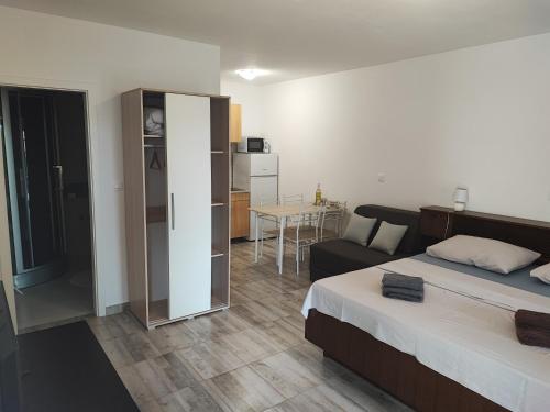 a bedroom with a bed and a living room with a couch at Deni09 in Pomer