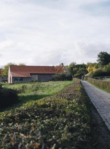 a road leading to a barn in a field at The Shepherds Farm in Heuvelland