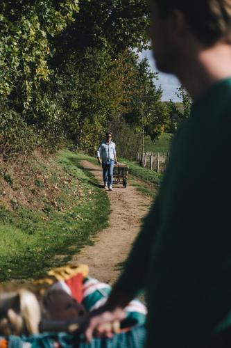 a man walking down a dirt path with a bench at The Shepherds Farm in Heuvelland