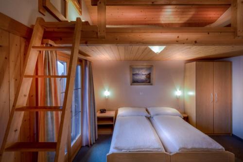 1 dormitorio con litera y escalera en Hotel Wildbach Brienz, en Brienz