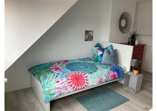 1 dormitorio con 1 cama con sábanas y almohadas coloridas en Seeadler, en Bremerhaven