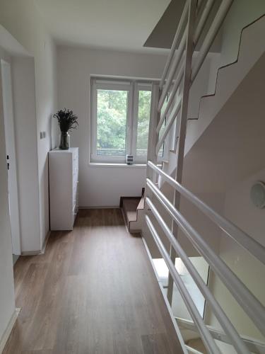 a staircase in a white room with a window at Chalupa u Martina in Vápenice