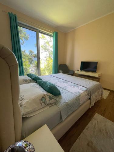 a bedroom with a bed with a window and a laptop at Glass house in Ulcinj