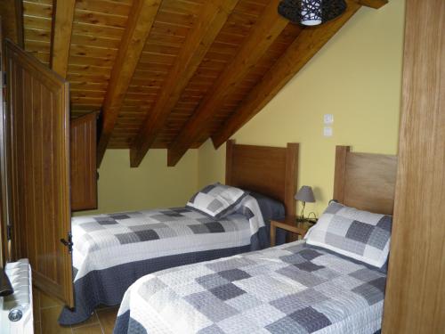 dos camas sentadas una al lado de la otra en un dormitorio en Apartamentos Turísticos Peñafiel en Peñafiel