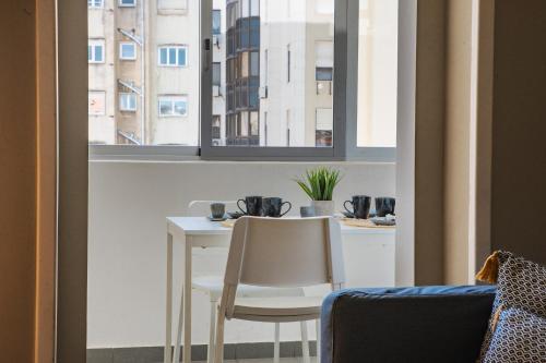 a table and two chairs in a room with a window at Succeed Campo Pequeno Guest House in Lisbon