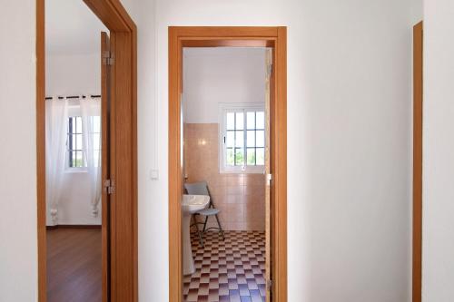 a door leading into a bathroom with a sink at Quinta Alegre Tavira T3 in Luz de Tavira