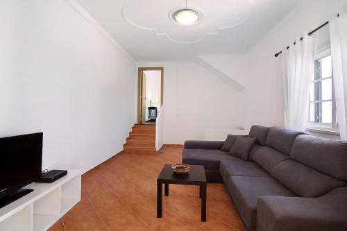 a living room with a couch and a tv at Quinta Alegre Tavira T3 in Luz de Tavira