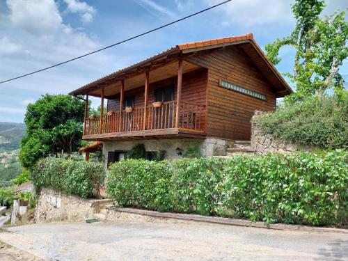 a wooden house with a balcony on a hill at Casa de Sao Joao in Gandarela