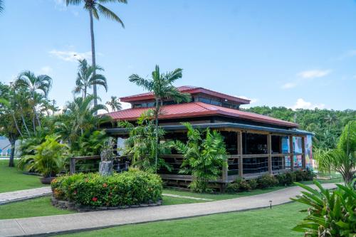 a building in a park with palm trees and grass at Parador El Faro in Aguadilla