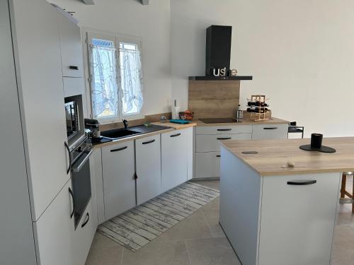 uma cozinha branca com armários brancos e um balcão em Location du Klan des K : villa 4 étoiles 150m plage em Les Sables Vignier