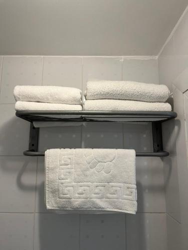 three towels are on a shelf in a bathroom at True Man Beach Apartments in Odesa