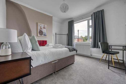 a bedroom with a bed with a desk and a window at Stylish Home - Fast Wi-Fi-FREE Parking in Nottingham