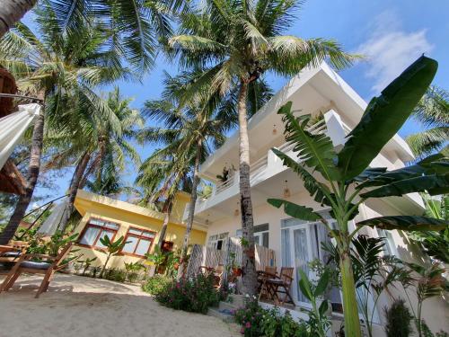Lucky Spot Beach Bungalow في Song Cau: منزل على الشاطئ مع أشجار النخيل