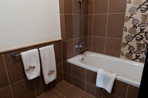 bagno con vasca e 2 asciugamani di Mivida Emaar - Residence by Elegant Hospitality a New cairo