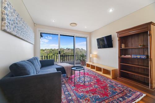 a living room with a couch and a large window at GRAND APARTMENT by the Harbor in Sydney