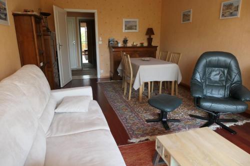 ein Wohnzimmer mit einem Sofa, einem Tisch und Stühlen in der Unterkunft Cosy cocoon with terrace near the sea in Arcachon