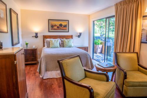 a hotel room with a bed and two chairs at Inn at Buckhorn Cove in Little River