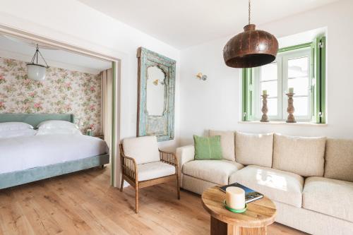 Vila Nova da Baronia的住宿－The Green House Alentejo by Santiago de Alfama，一间卧室配有一张床、一张沙发和一张桌子