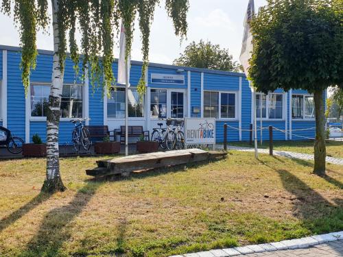 a blue building with a bench in front of it at slube am Yachthafen Greifswald in Greifswald