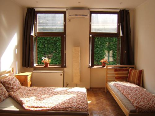 a bedroom with two windows and a bed in it at BZE Apartment in Budapest