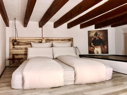 1 cama blanca grande en una habitación con techos de madera. en Dog Admiral - Urban Guest House en Palma de Mallorca