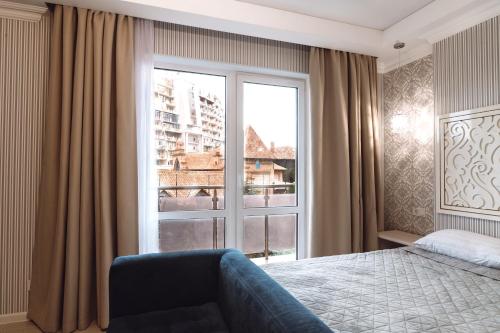 a bedroom with a bed and a large window at Arcadia Gold in Odesa