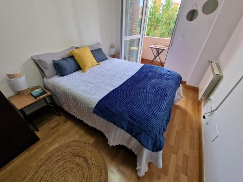 a bedroom with a bed with blue and yellow pillows at Piso Al Norte in Treto