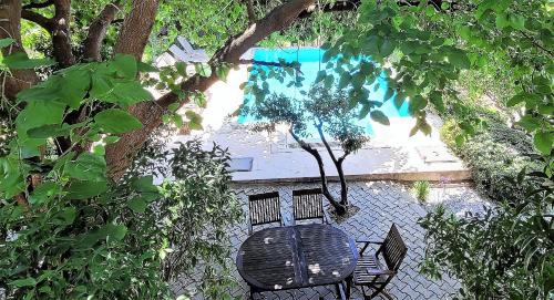 a black table and chair under a tree at Muskebi Villa in Ortakent