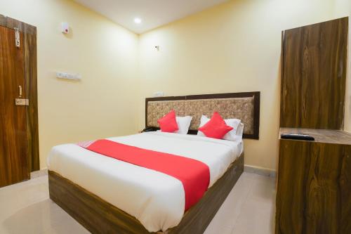 a bedroom with a large bed with red pillows at OYO R Square Stay Near LB Nagar Metro in Surūrnagar