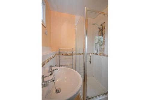 y baño con lavabo y ducha. en Tan Dinas Lodge en Benllech