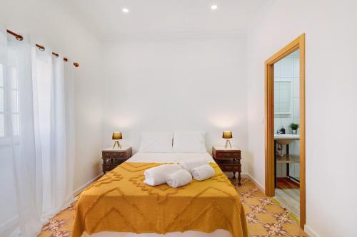 a bedroom with a bed with two towels on it at Quinta Alegre Tavira Moderno T2 in Luz de Tavira