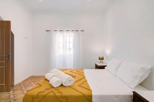 a bedroom with a bed with two towels on it at Quinta Alegre Tavira Moderno T2 in Luz de Tavira