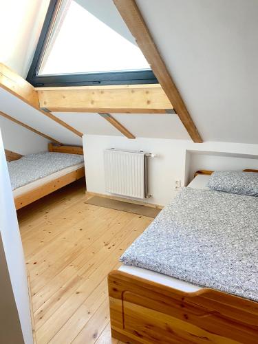 1 dormitorio en el ático con 2 camas y ventana en Apartment Steinwänd Top 8, en Grünau im Almtal