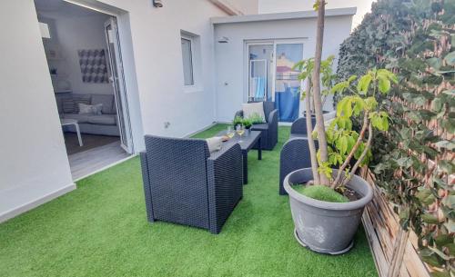 un patio con mesa, sillas y una maceta en Terraza de Santa Cruz, en Santa Cruz de Tenerife