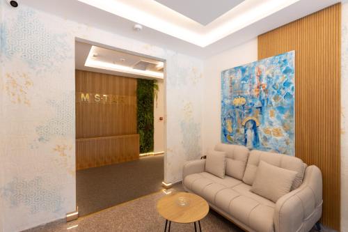 a living room with a couch and a painting at Hotel M Star Novi Pazar in Novi Pazar