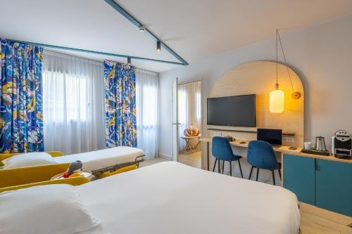 a hotel room with two beds and a desk at Urban Hotel & Spa Aix-les-Bains - BW Signature Collection in Aix-les-Bains