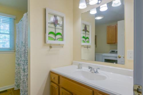 un baño con lavabo y espejo en 132 Hooppole Road Mashpee Indra Cottage, en Mashpee