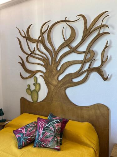 a bedroom with a tree mural on the wall at Agrolea in Terme Vigliatore