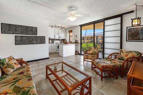 a living room with a table and chairs and a kitchen at Kona Makai 6204 in Kailua-Kona