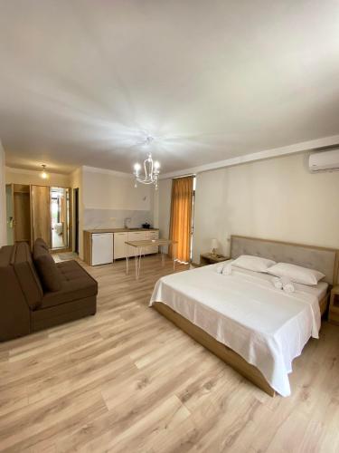 ein großes Schlafzimmer mit einem Bett und einem Sofa in der Unterkunft Panorama Bajo Shekvetili in Shekhvetili