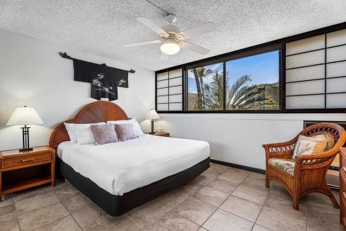 a bedroom with a bed and a large window at Kona Makai 6204 in Kailua-Kona