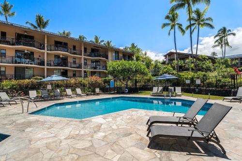 a swimming pool with chairs and a hotel at Kona Makai 6204 in Kailua-Kona