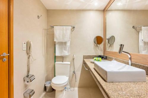 a bathroom with a sink and a toilet and a phone at Flat completo e charmoso Brasil 21 Suítes in Brasilia
