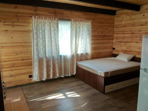 a small bedroom with a bed and a window at Воллен in Zhvanets