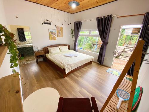 a bedroom with a bed and a large window at Oak Village by D Home Da Lat in Da Lat