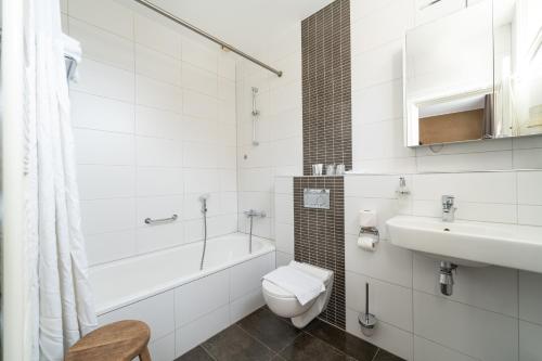 a white bathroom with a toilet and a sink at Hotel Montfoort in Montfoort